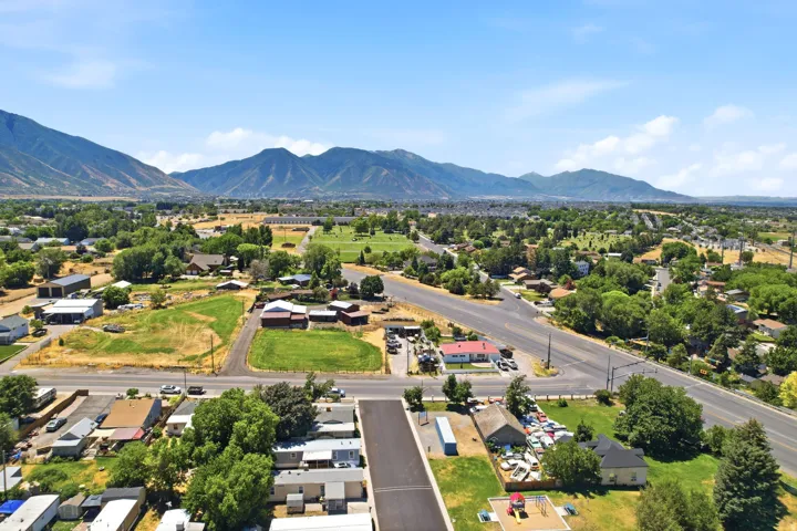 Expansive aerial perspective showcasing a rural-suburban landscape framed by distant mountains