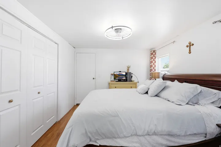Bright interior space featuring wood-finish flooring, white walls, and a modern ceiling light fixture