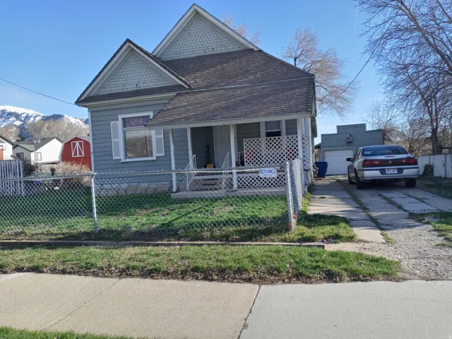 Light blue siding residence with a covered front porch featuring white lattice detailing