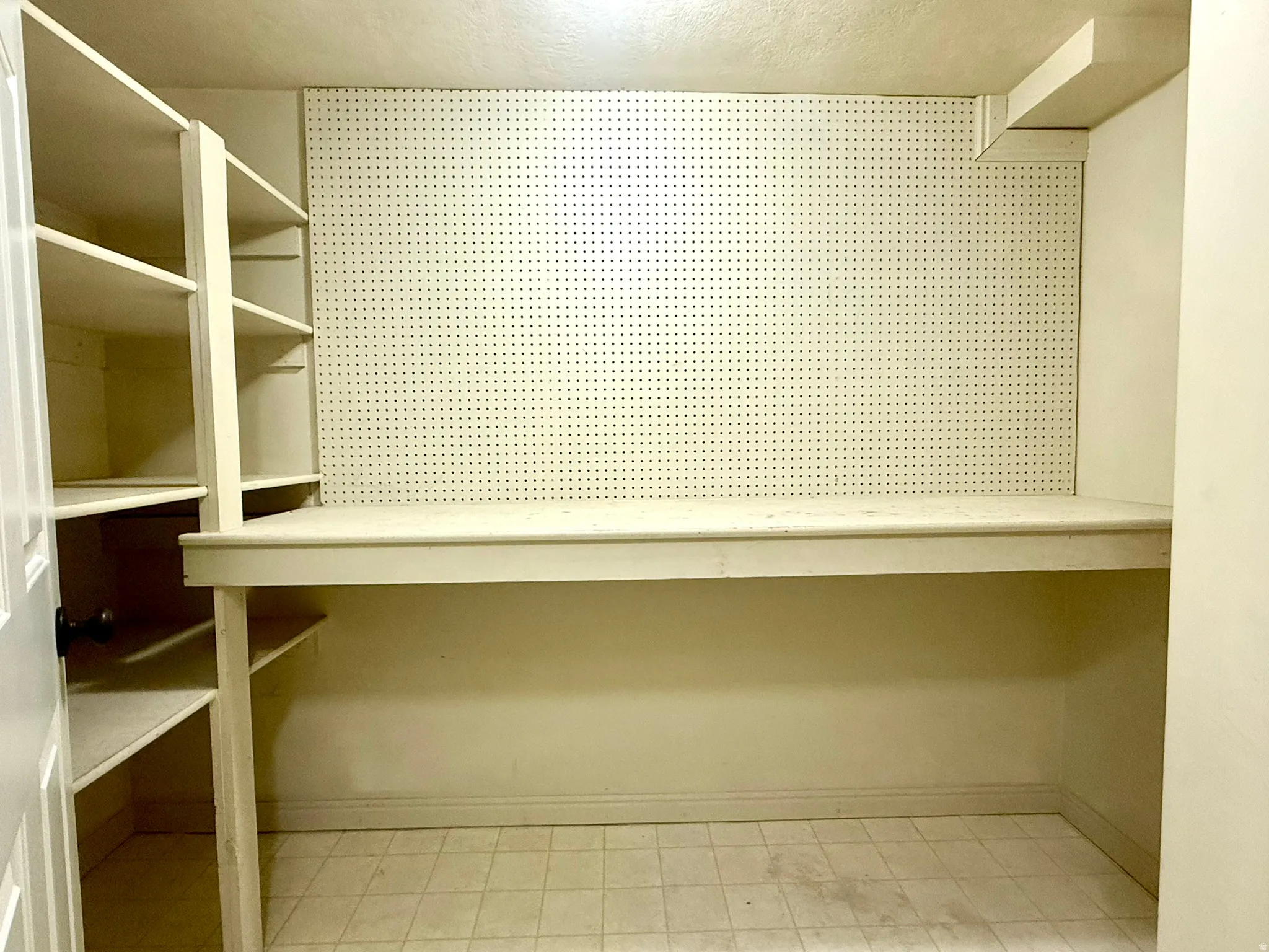 Built-in shelving and workbench with a pegboard backing