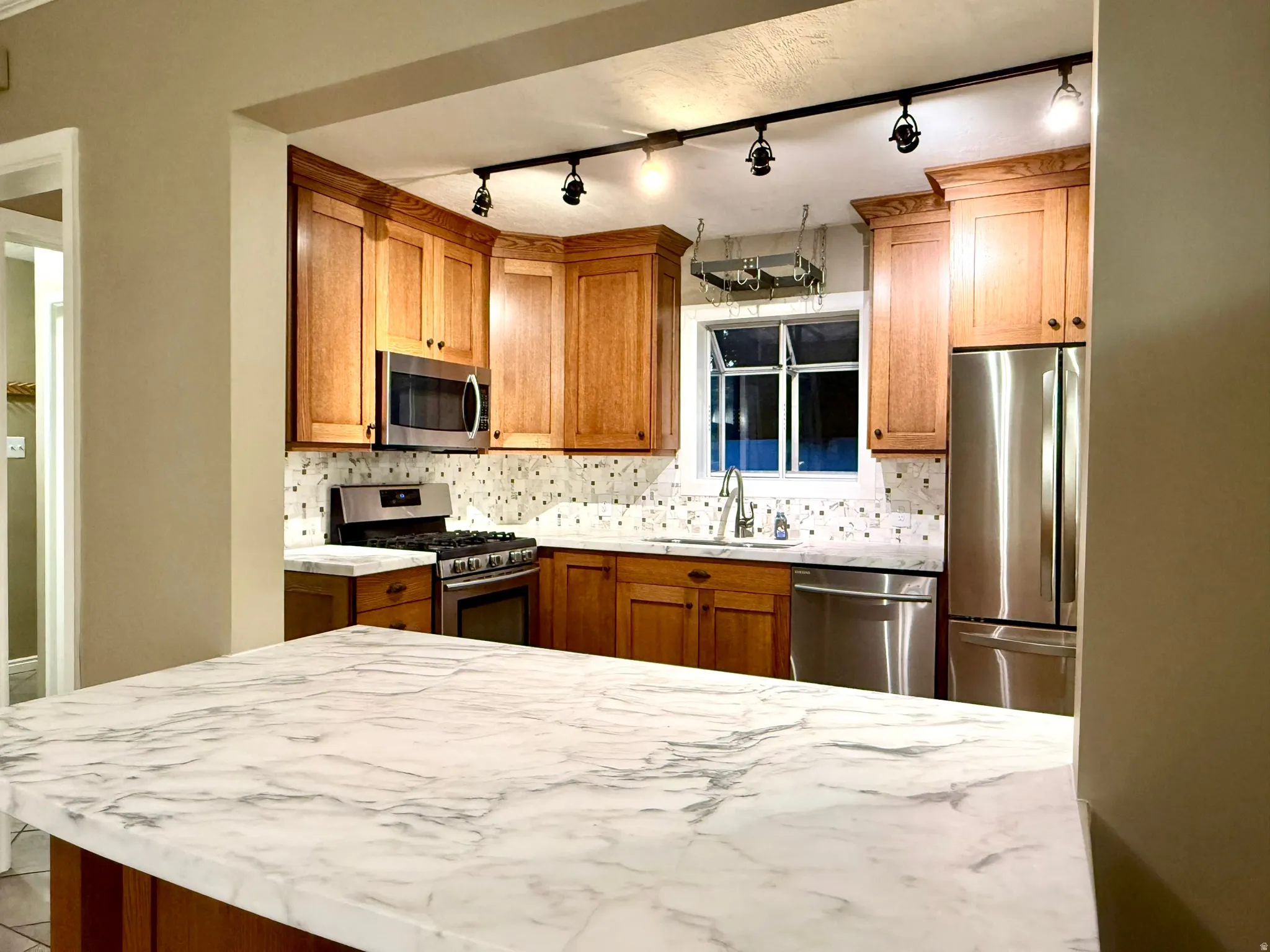 Kitchen featuring a spacious island with a marble-finish countertop