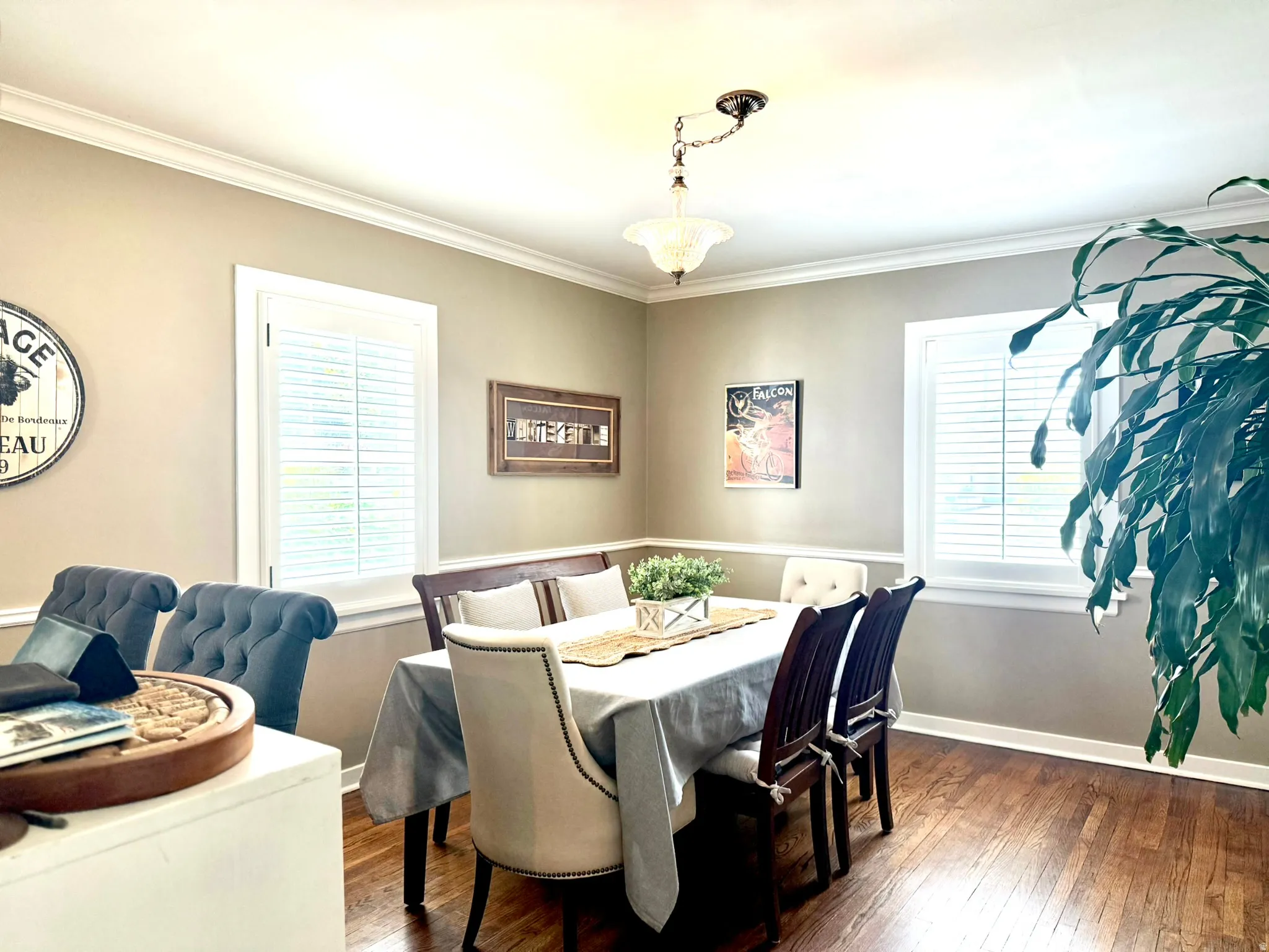 Dining area featuring hardwood flooring, crown molding, and two windows with plantation shutters