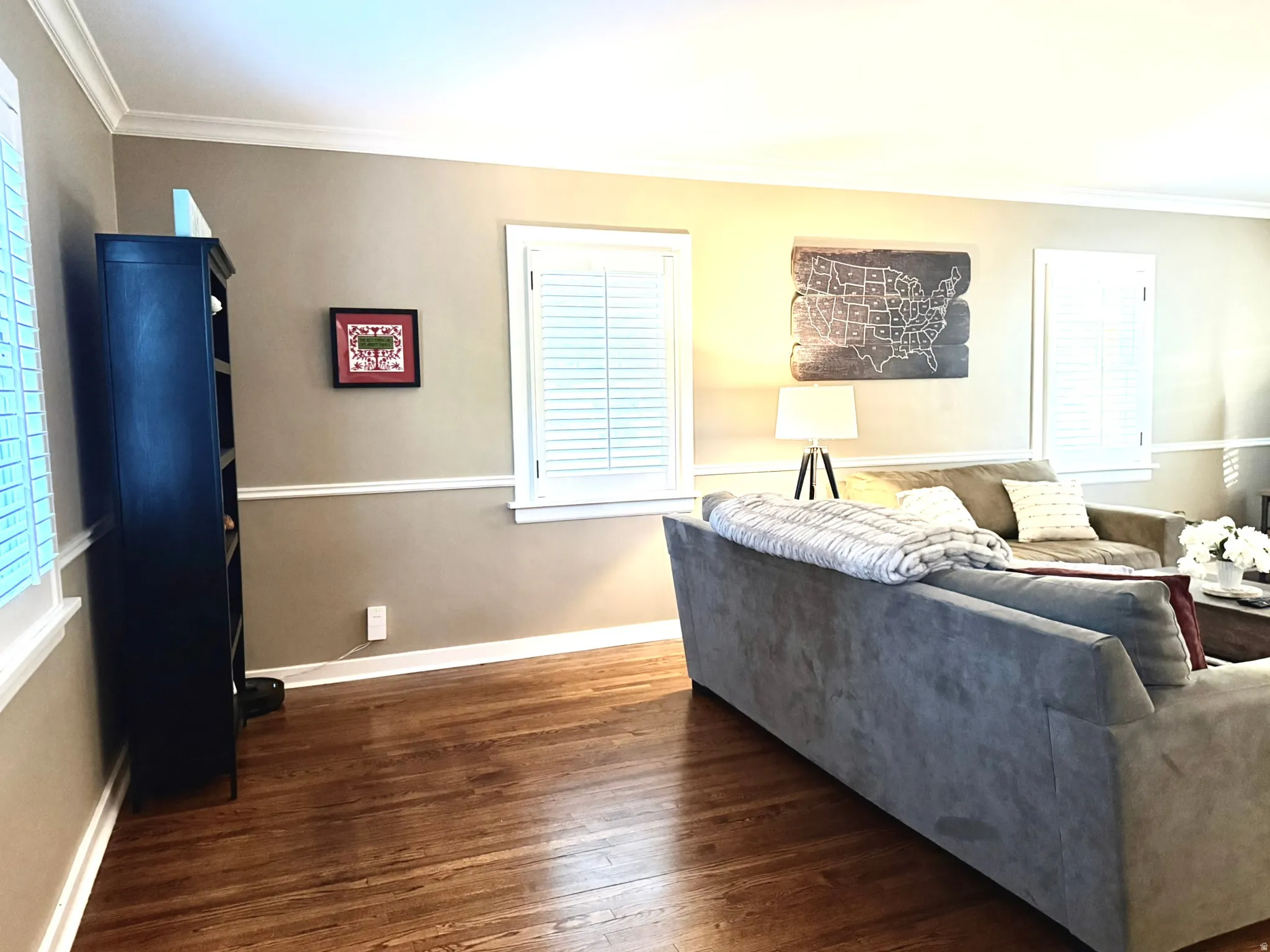 Rich wood flooring complements neutral wall tones in this inviting living area