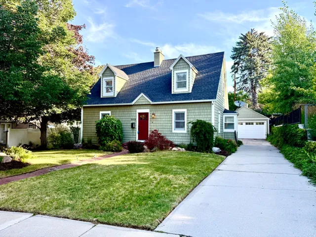 Gabled roofline with dormer windows atop a green shingle exterior