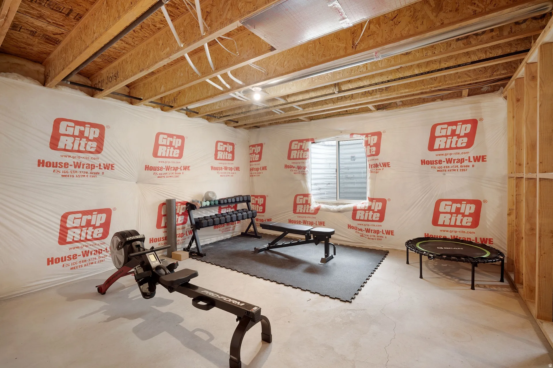 Unfinished basement space featuring exposed wood joists and concrete flooring, offering expansive potential