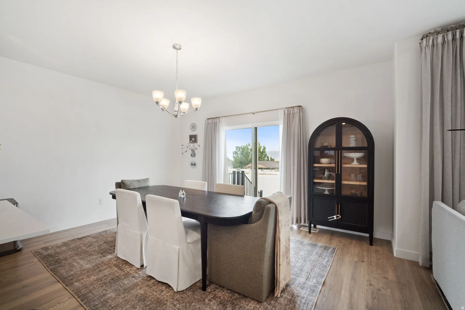Formal dining area featuring wood-finish flooring and a contemporary chandelier