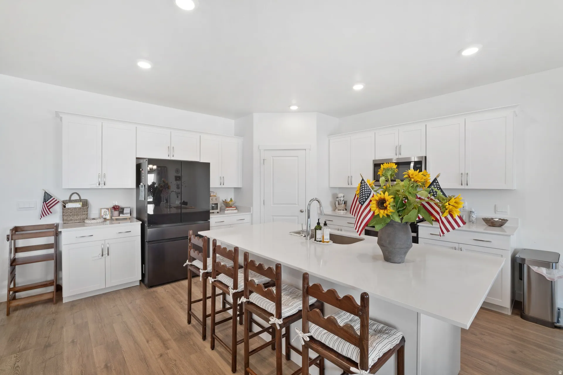 Modern kitchen featuring an expansive island with seating, integrated sink, and stainless-steel faucet