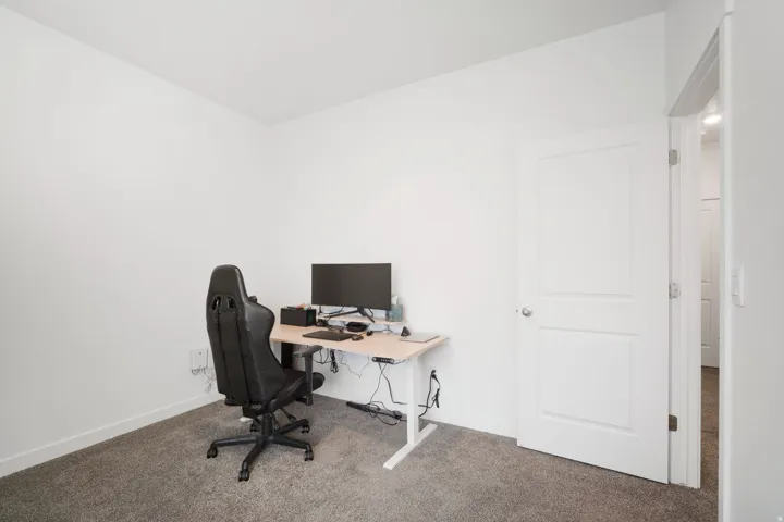 Neutral wall tones with carpeted flooring and a two-panel interior door