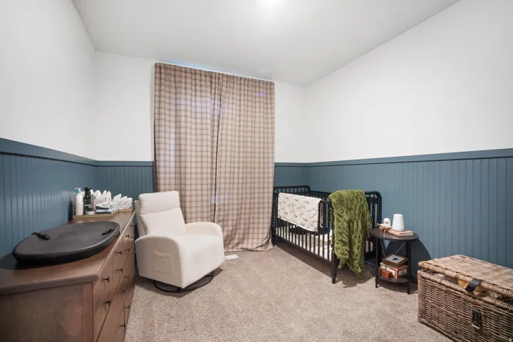 Bedroom featuring a two-tone wall treatment with a beadboard wainscoting and smooth upper wall