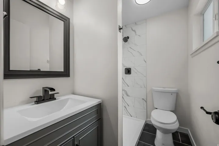Bathroom featuring a dark gray vanity with a white countertop and integrated sink