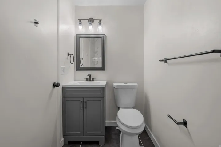 Bathroom featuring a modern gray vanity with a white countertop and integrated sink