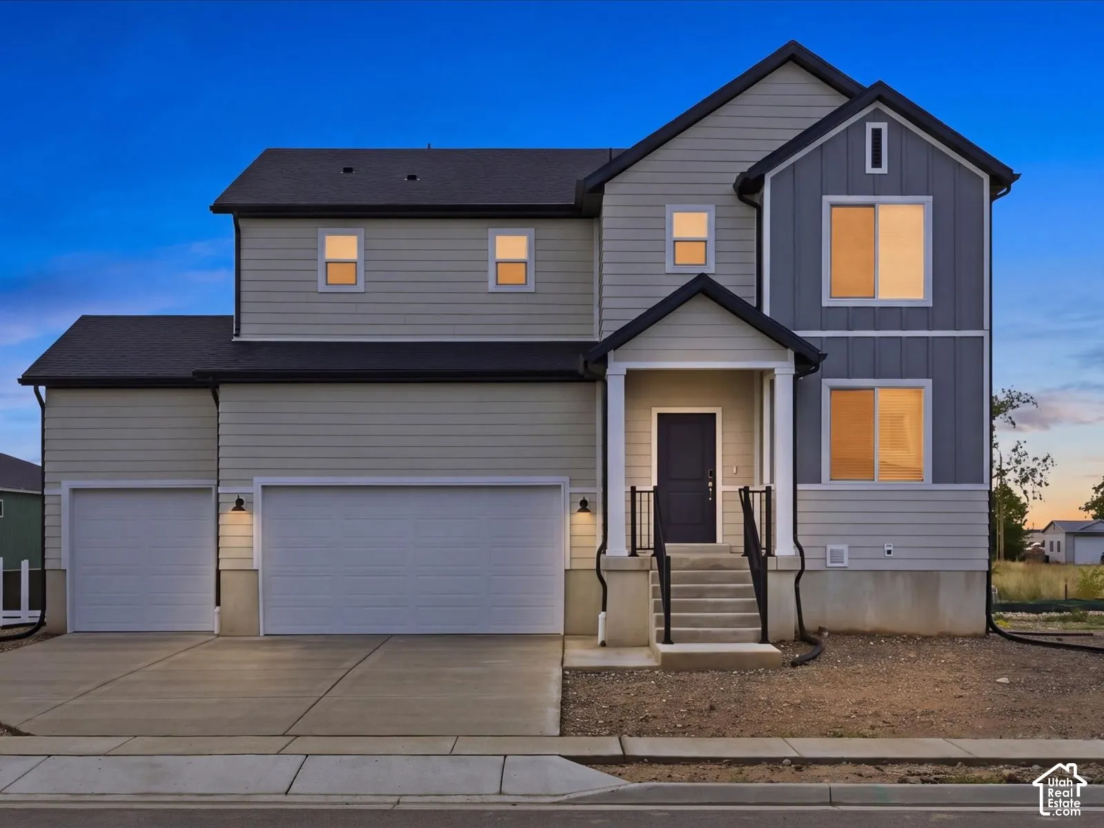 Two-story exterior featuring a mix of horizontal lap siding and vertical board-and-batten siding, a covered entryway with column supports, and a three-car garage