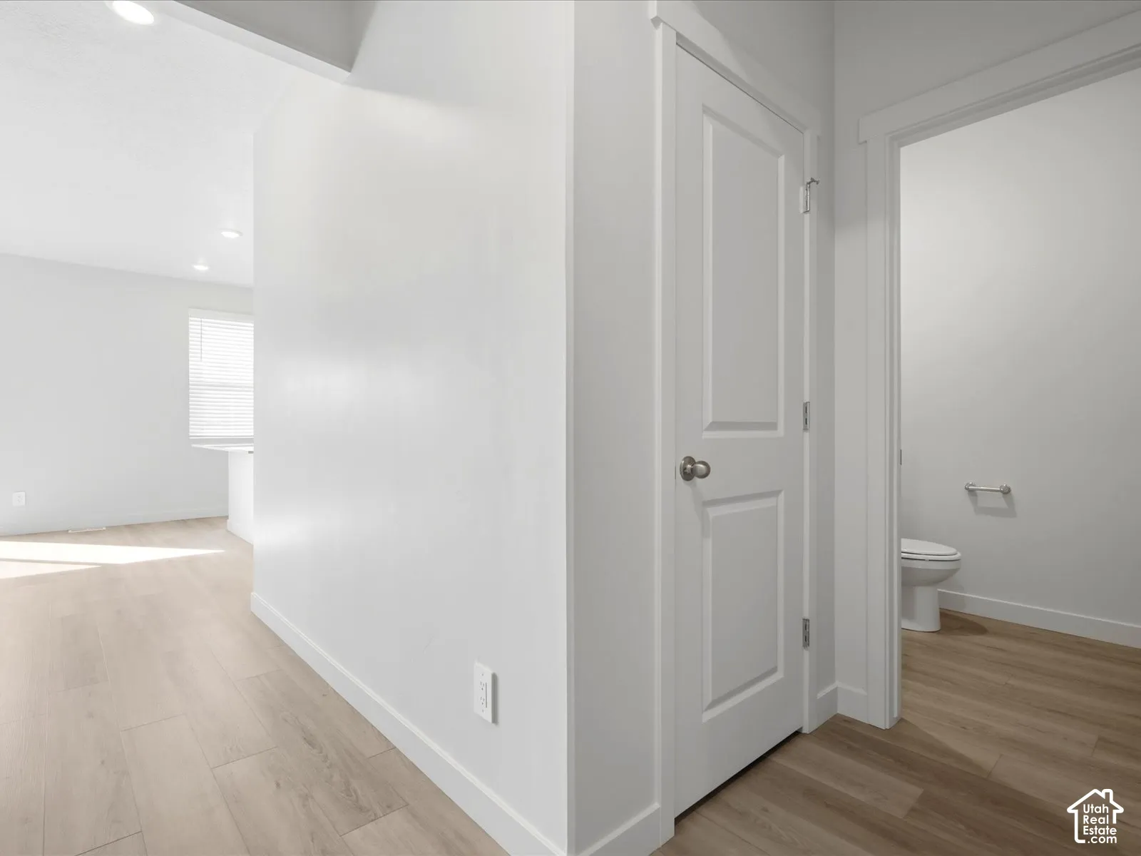 Interior space featuring wood-finish flooring, two-panel interior doors, recessed ceiling lighting, and neutral wall tones