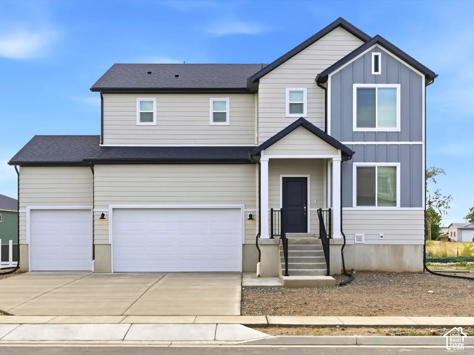 Multi-level exterior featuring horizontal siding and vertical paneling, a three-car garage, and a covered front porch with a concrete staircase