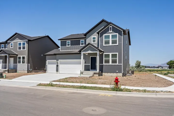 Contemporary two-story residence featuring a dark gray and light gray facade with vertical and horizontal siding