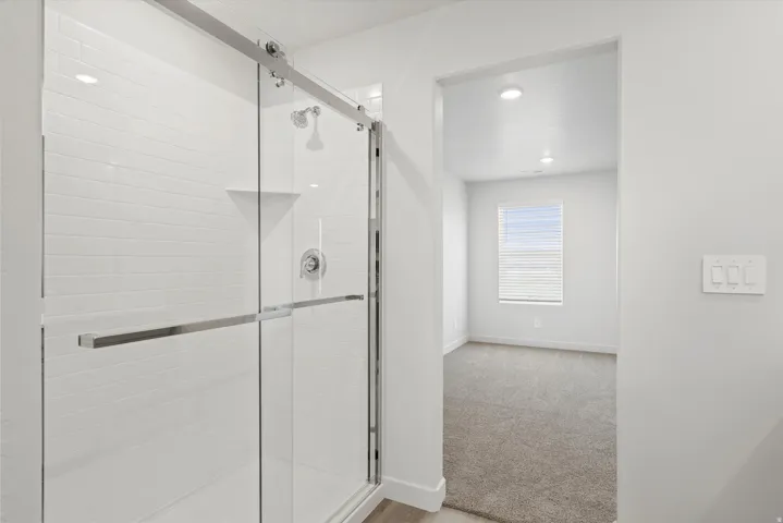 **DISCLAIMER** Interior package may vary. Frameless glass shower with sliding door and white subway tile surround