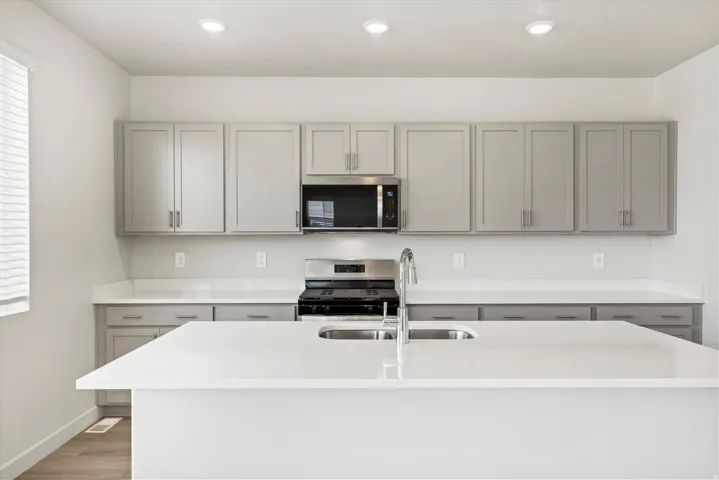 **DISCLAIMER** Interior package may vary. Modern kitchen featuring a large center island with an undermount double basin sink and gooseneck faucet