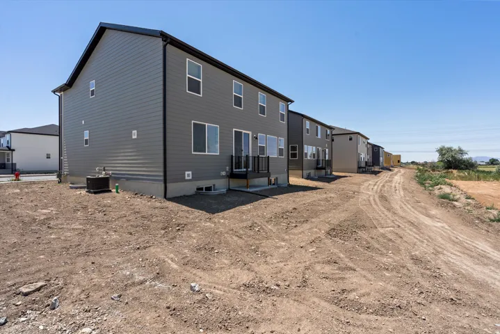Rear elevation featuring gray horizontal siding and a black roofline