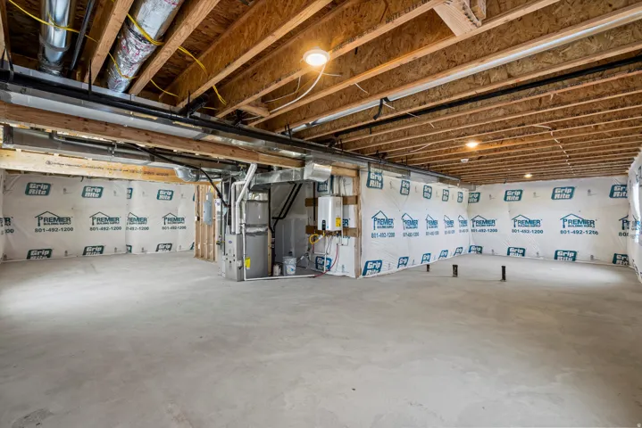 Unfinished basement offering exposed wood joists, concrete flooring, and visible ductwork