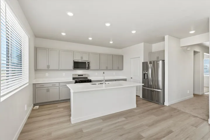 **DISCLAIMER** Interior package may vary. Modern kitchen featuring light gray cabinetry, white countertops, and stainless steel appliances