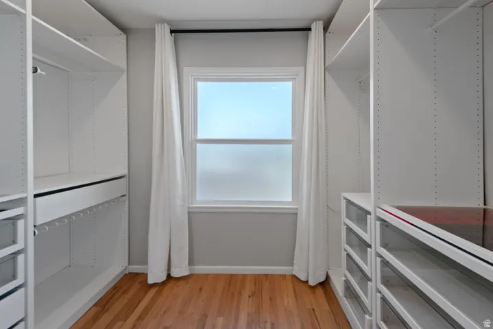 Custom walk - in closet featuring ample shelving, hanging rods, and built-in drawers