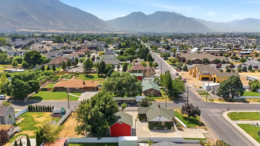 Mountain backdrop, residential neighborhood, established trees, paved streets, clear skies