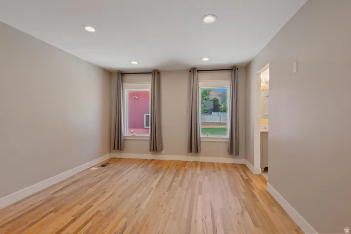 Spacious Primary Bedroom  with hardwood floors, recessed ceiling, new windows, walk-in closet and en suite bath.