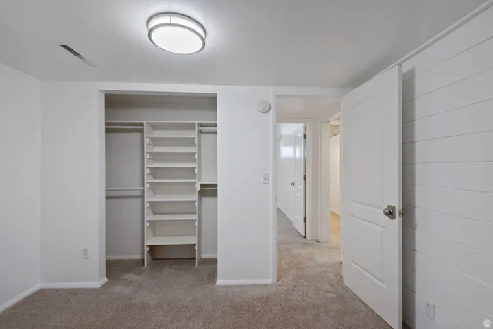 Recessed closet featuring built-in shelving and hanging rods