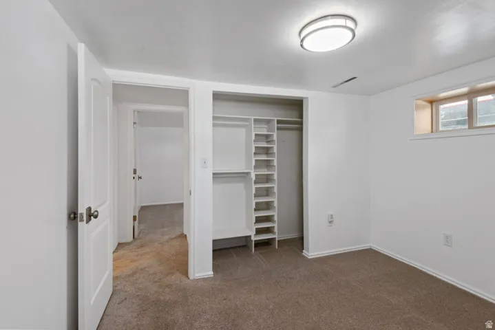 Bedroom with  built-in closet system with shelvin