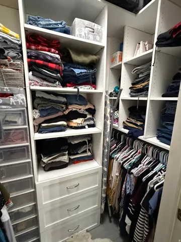 Master walk in custom closet organization system featuring white shelving units