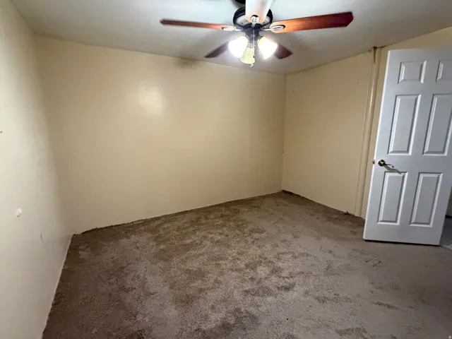 Interior space featuring light-colored walls and a ceiling fan with integrated lighting