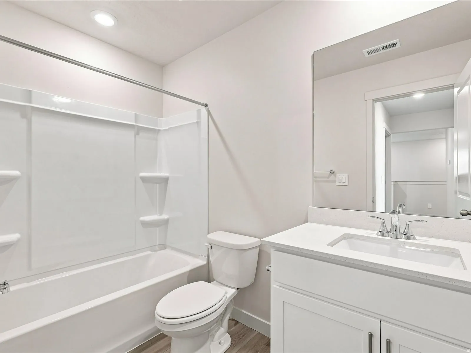 Bathroom featuring a white vanity with an integrated sink, polished chrome faucet, and white countertop