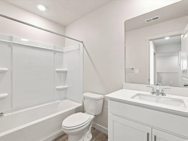 Bathroom featuring a white vanity with an integrated sink, polished chrome faucet, and white countertop