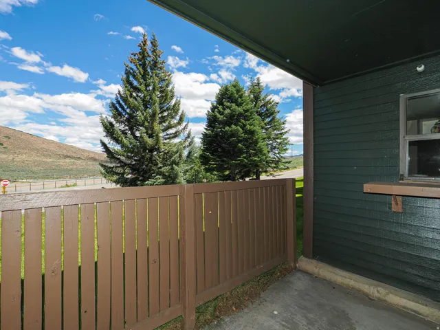 Covered patio featuring a concrete slab and a brown privacy fence