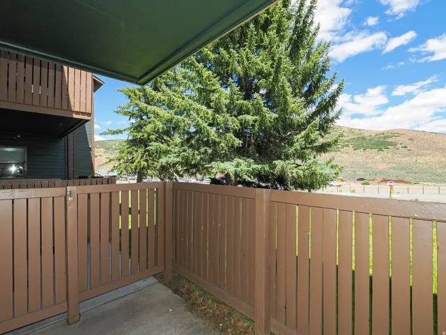 Private patio area featuring a brown slatted fence and concrete flooring