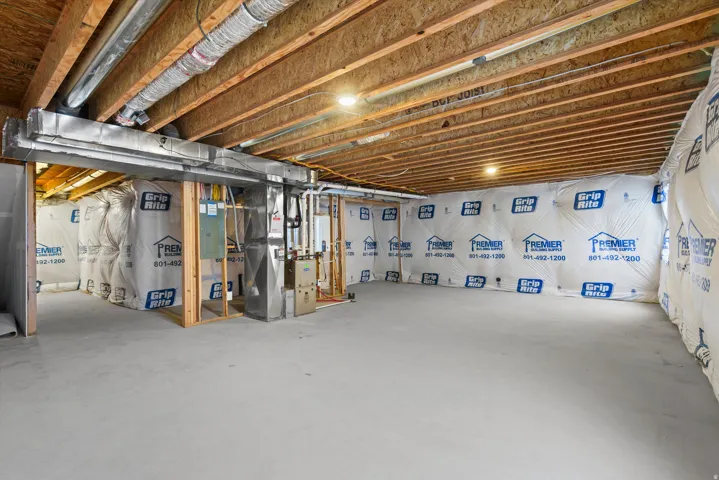 Unfinished basement with concrete flooring, exposed ceiling joists, recessed lighting, and insulated perimeter walls
