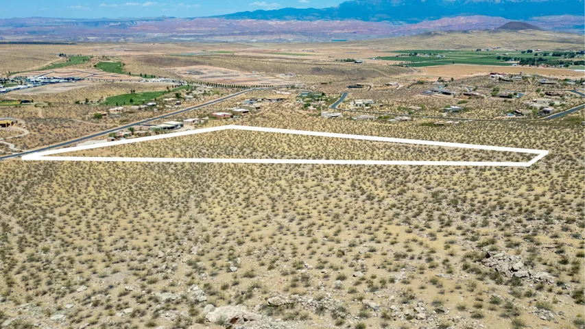 Expansive land parcel outlined in white, featuring natural desert vegetation and distant mountain ranges