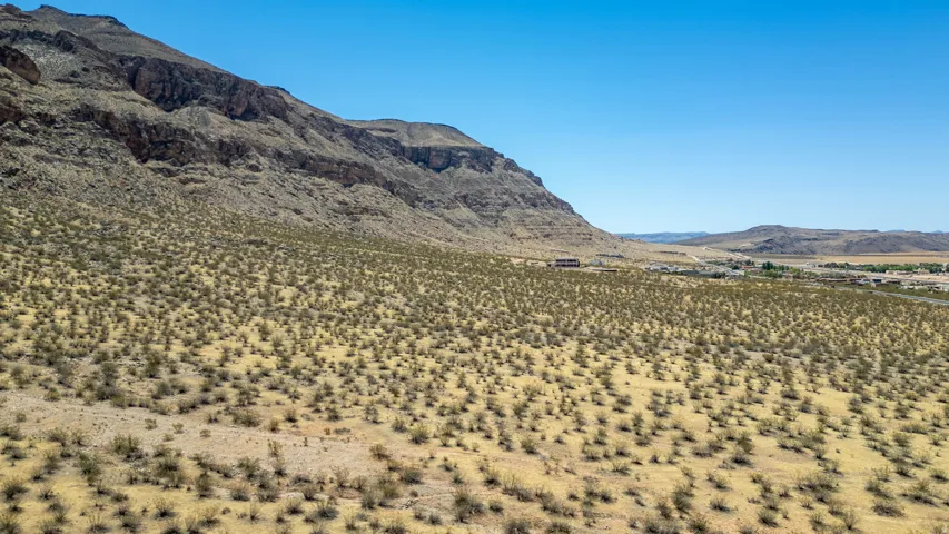 Expansive desert landscape featuring natural rock formations and a distant settlement