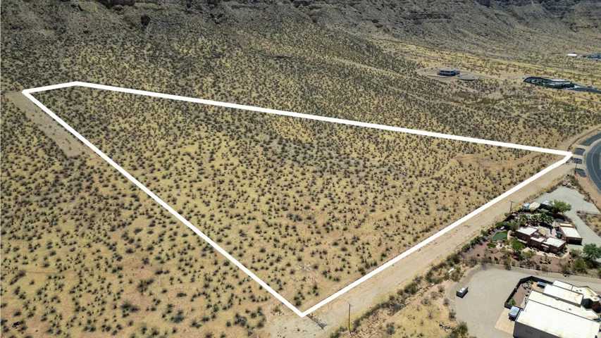 Expansive desert lot featuring a large, irregular shape and surrounding natural terrain