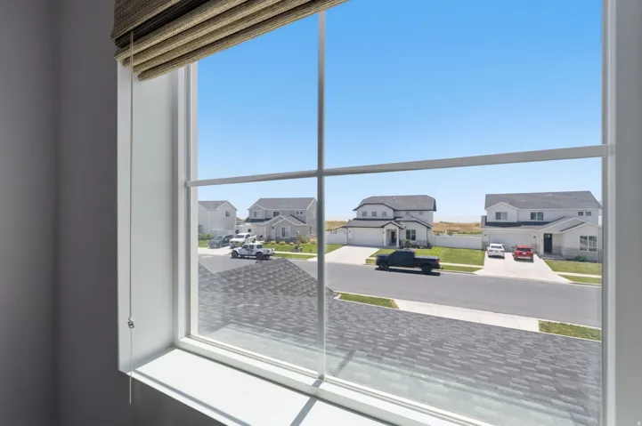 Large multi-pane window with white framing, offering expansive views of the surrounding residential area
