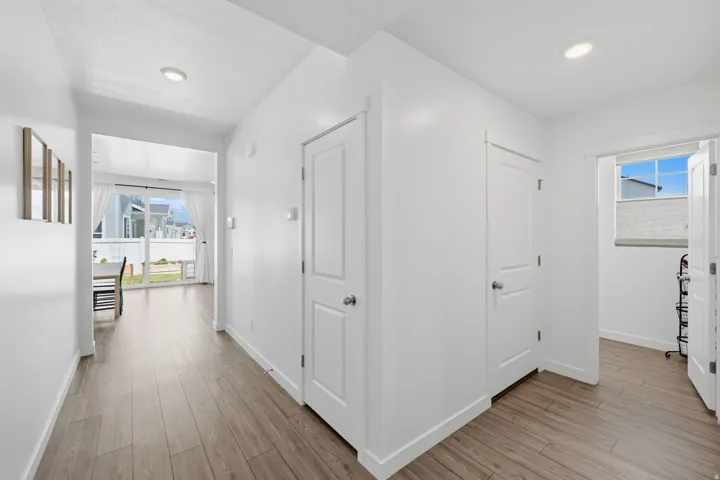 Hallway featuring wood-finish flooring, recessed lighting, white walls, and white trim