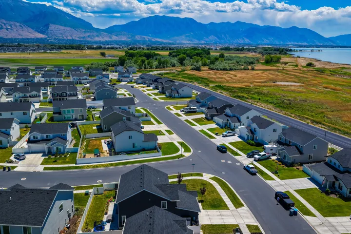 Aerial perspective showcasing a developed residential community with dark asphalt streets and light concrete sidewalks