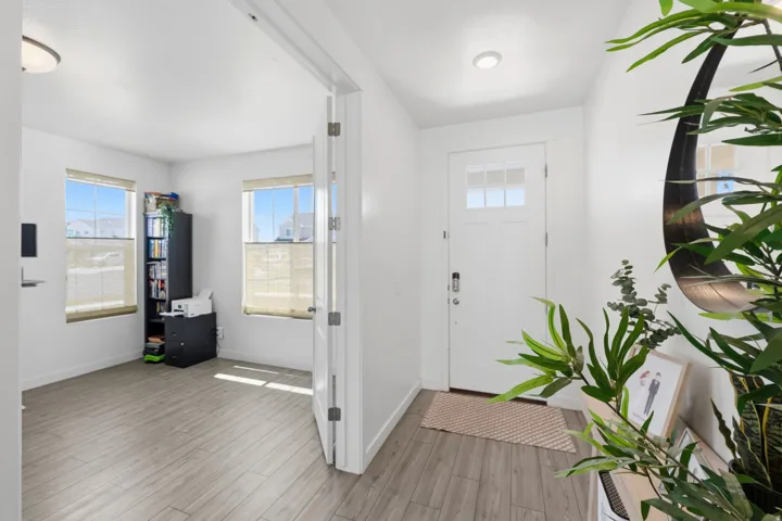 Entryway featuring a paneled door with glass inserts, wood-finish flooring, and white walls