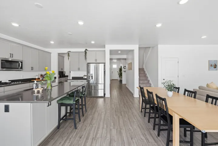 Open-concept living area featuring wood-finish flooring, recessed lighting, and a neutral color palette
