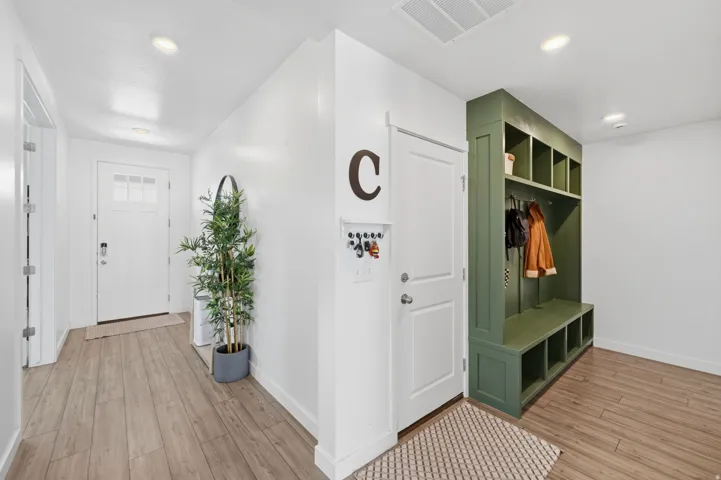 Entryway featuring wood-finish flooring and a white paneled front door with frosted glass