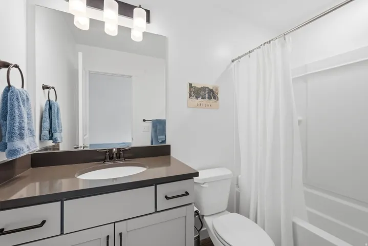 Bathroom featuring a vanity with an integrated sink, dark countertop, and dark-finish hardware