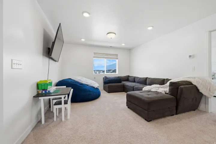 Carpeted recreation area featuring recessed lighting and a window with mountain scenery