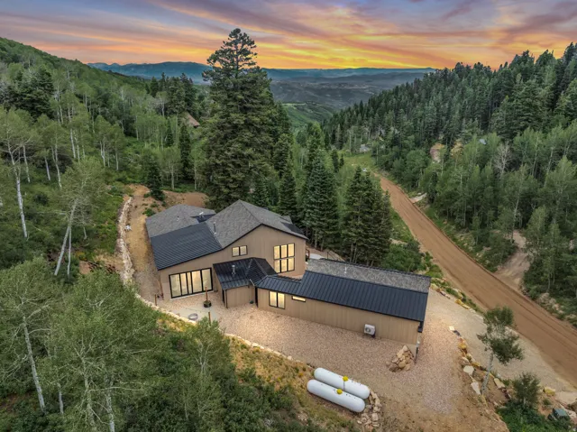 Modern mountain residence featuring a multi-level design and a combination of shingle and metal roofing