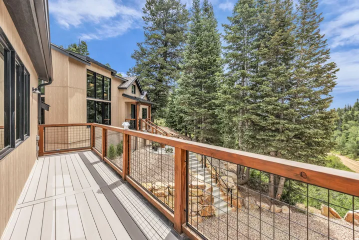 Outdoor deck featuring composite decking and a wood railing with black mesh infill