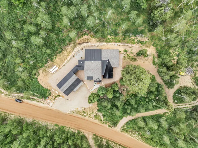 Contemporary residence with a multi-level roofline, surrounded by dense natural foliage